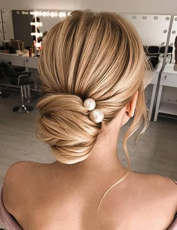 blonde bride wearing her hair in a low bun with small pearl hair accessory