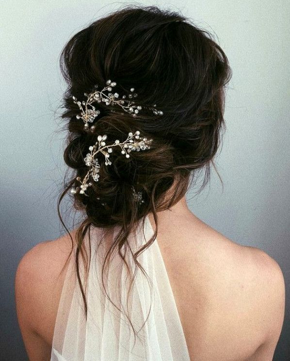 brunette bride wearing her hair in a messy low bun with delicate hair accessory