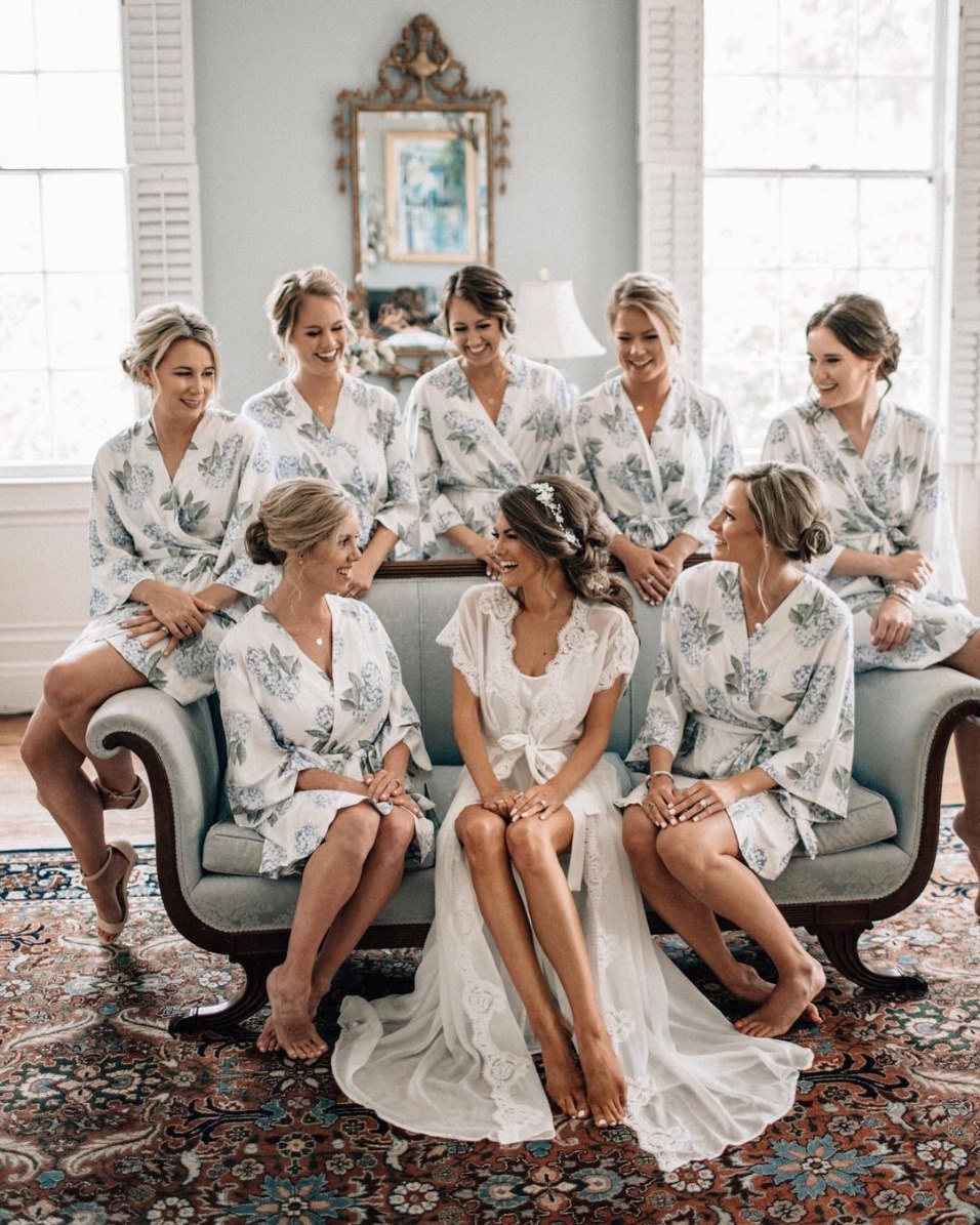 bridal party and bride getting ready photo wearing robes seating on a couch