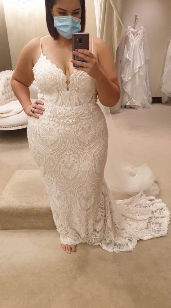 Curvy bride trying on wedding dress
