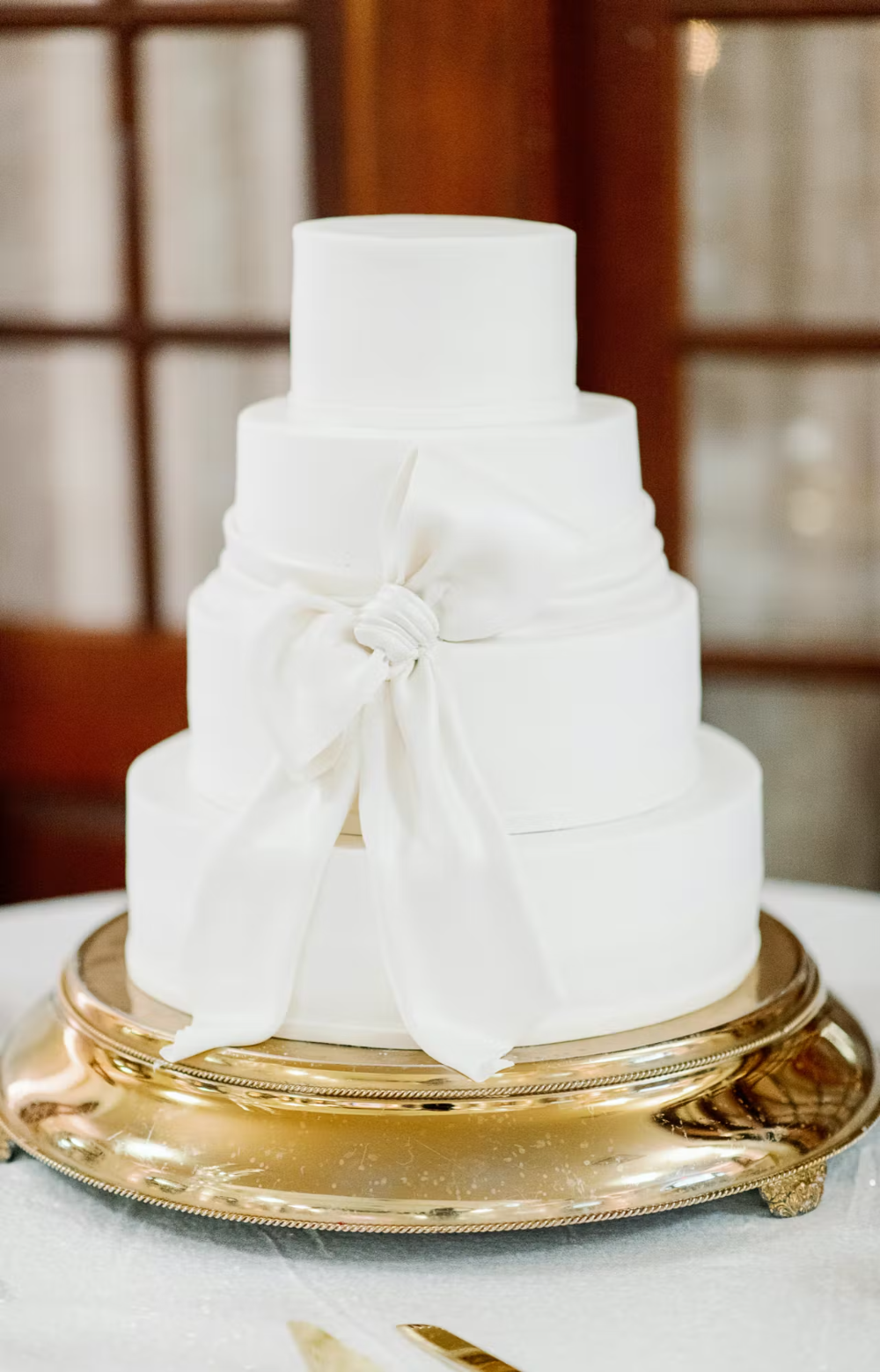 Wedding ideas with the color white: white wedding cake on gold stand