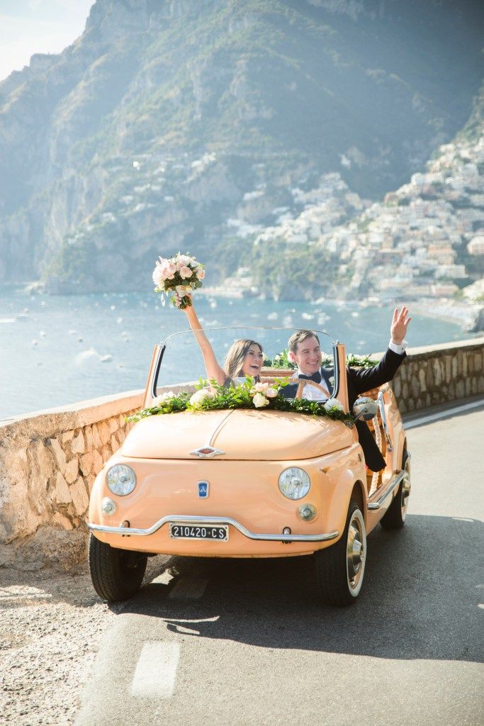 bride and groom in a peach old convertible car in Positano, Italy